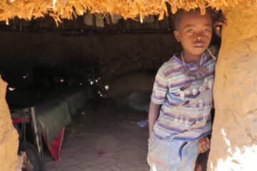 Boy from Darfur, Sudan looking out from his hut