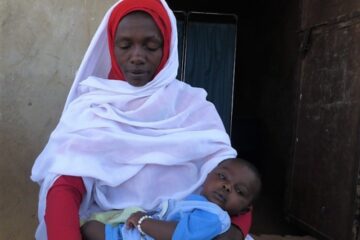Midwife in Darfur holding a baby